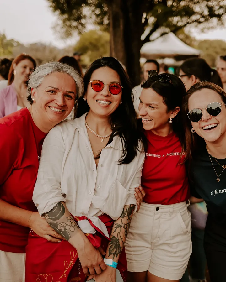 Ana Lisboa sorrindo com um grupo de alunas