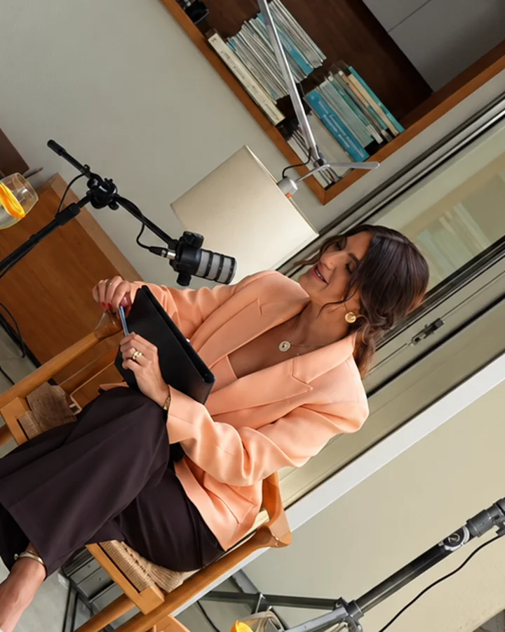 Ana Lisboa gravando podcast, sentada com tablet no colo